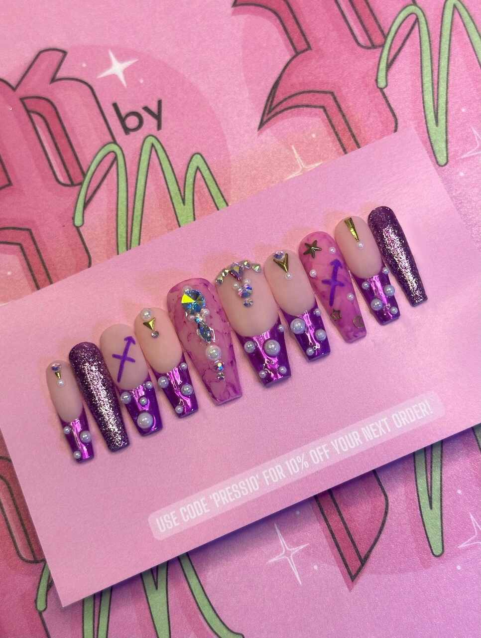 Unhas postiças para sagitário: unhas nudes com decoração em roxo e púrpura com strass e glitter 