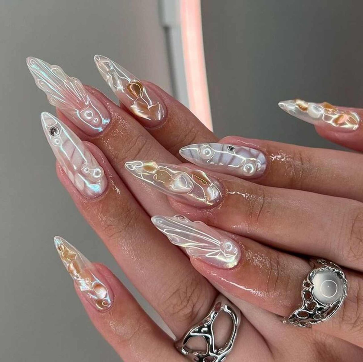 Unhas grandes pérolas com ostras, dourado e decoração furta cor