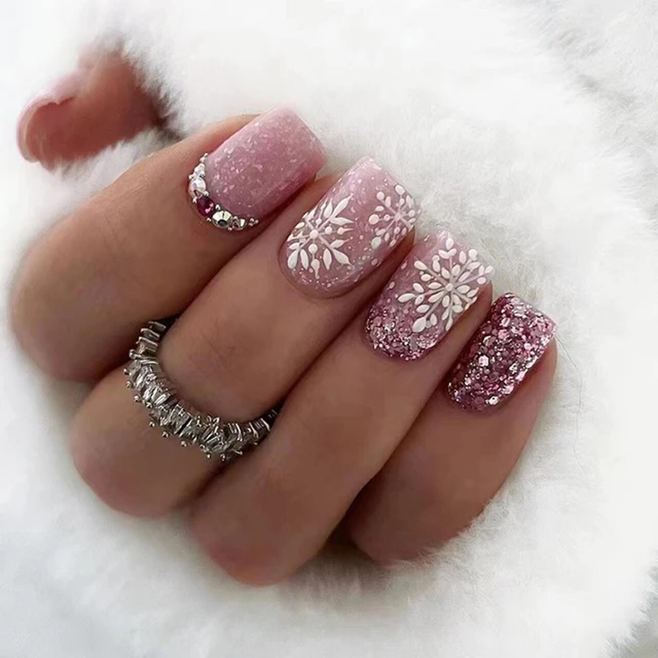 Unhas curtas com glitter rosa e flocos de neve brancos