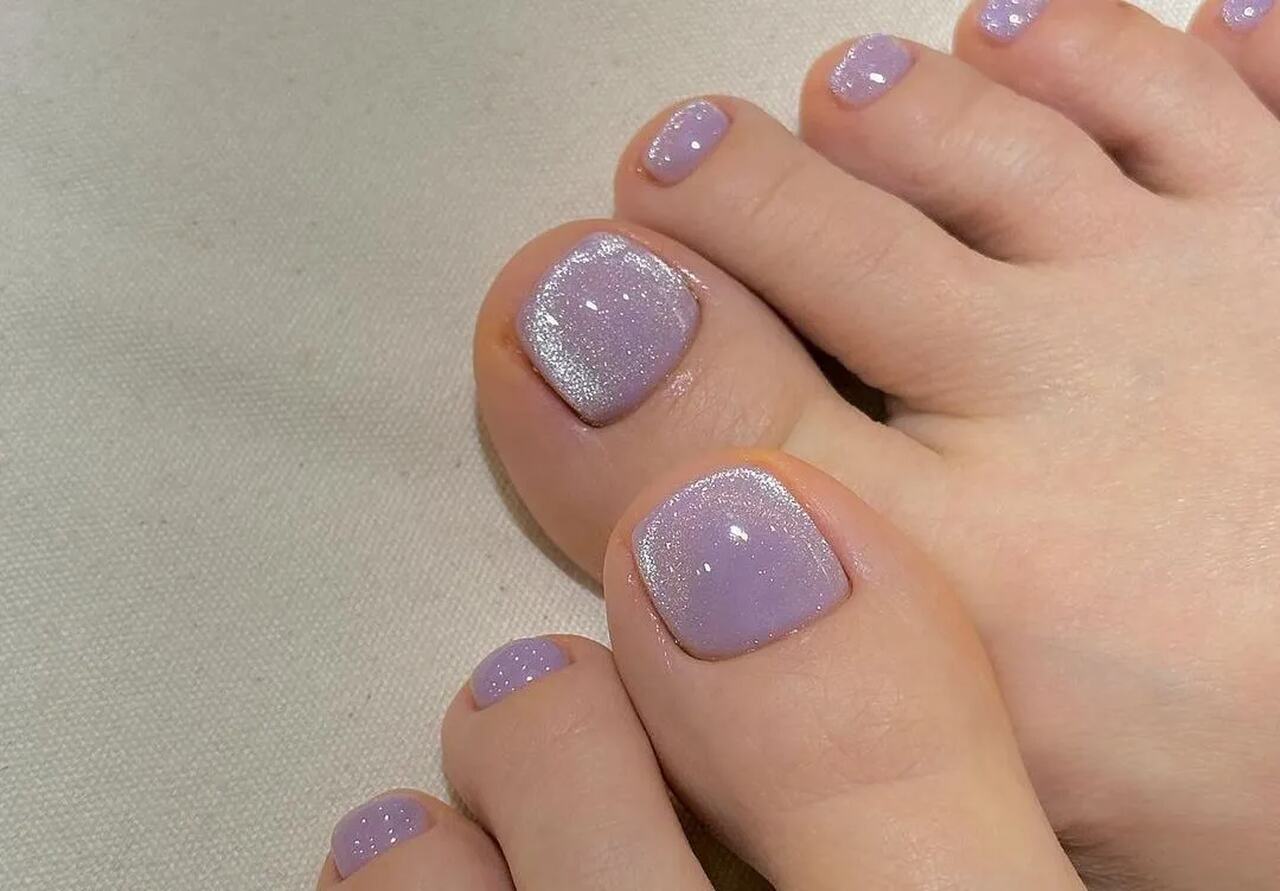 Unhas dos pés delicadas com lilás e furta cor