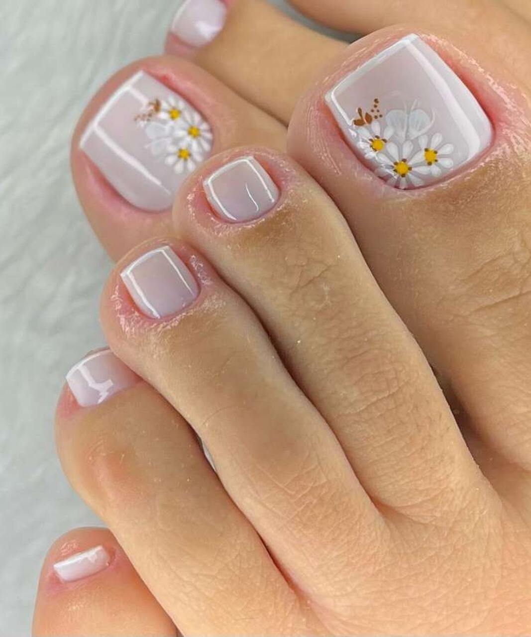 Unhas dos pés brancas com francesinha e decoração com flores brancas