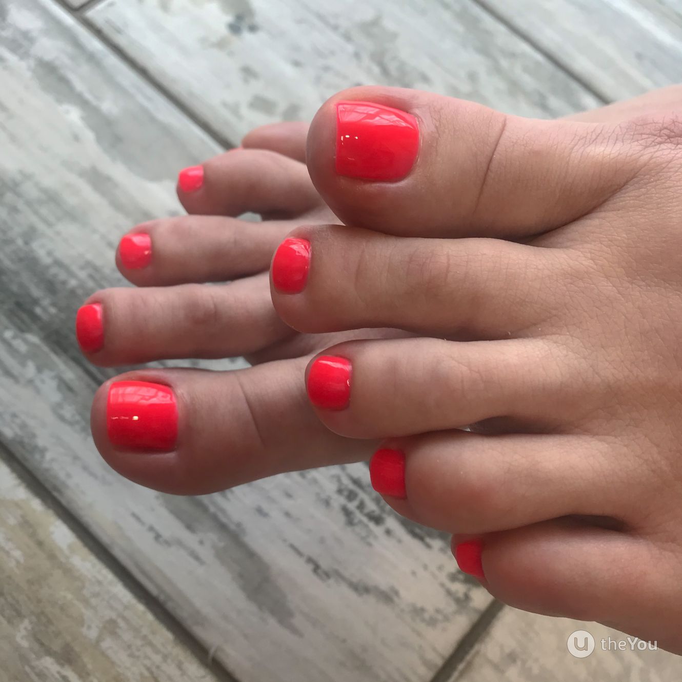 Unhas dos pés com esmalte coral